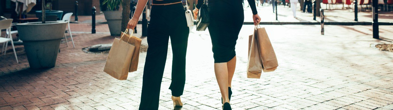 Two women walking with shopping bags.