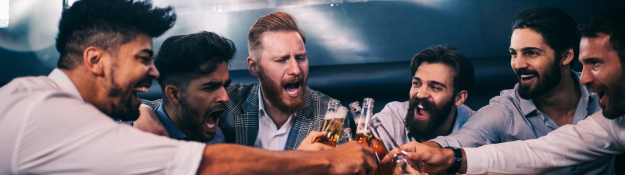 A group of men, toasting drinks.